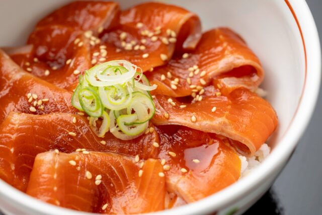 ///ASOサーモンの漬け丼///

阿蘇の澄んだ水で育ったトラウトサーモン（虹鱒）を、自家製のたれに漬け込んだ、「ASOサーモンの漬け丼」です。
臭みがなく、ねっとりとした味わいで、自家製の柚子胡椒を少しのせると、旨みがすっと引き立ちます。
小鉢、サラダ、味噌汁、漬物付きのヘルシーな一汁一膳のごはんです。

ごはんも汁ものも、少しずつ食べてみたいという方には、「米粉のおうどんとミニ丼のセット」があります。
「米粉のおうどん＋ミニASOサーモンの漬け丼 」もぜひお召し上がりください。おうどんには、お好きな具材を追加できます（別料金）。
 朝晩の冷え込みが深まる季節。温泉であたたまったあとは、阿蘇の恵みをまるごと味わえる一膳をどうぞ。